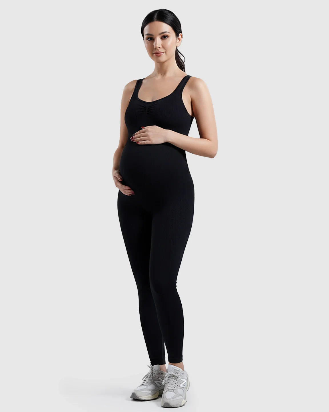 Black ribbed high-waisted maternity bodysuit on a pregnant model, featuring a comfortable stretch fit.