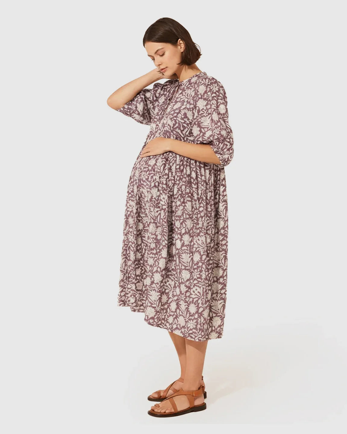 Pregnant woman in a loose-fit, gathered shoulder floral maternity midi dress with puff sleeves.