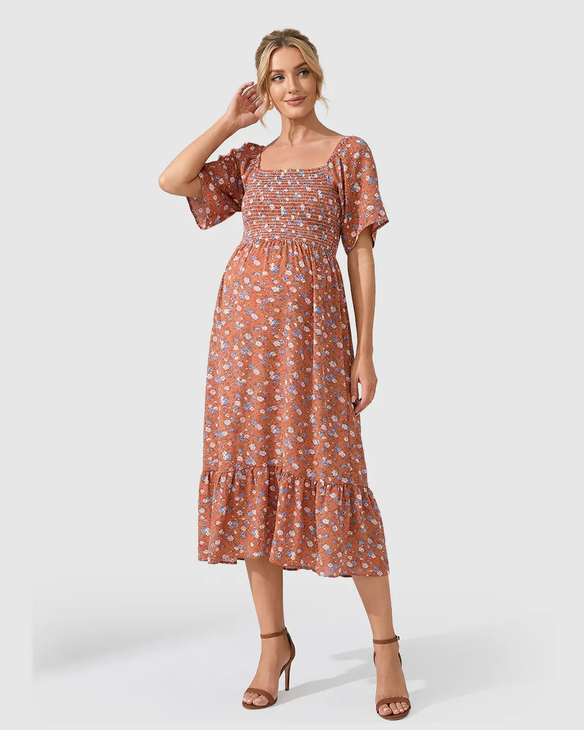 Flutter-sleeve smocked maternity midi dress in rust with blue floral print, tiered skirt, and square neckline.
