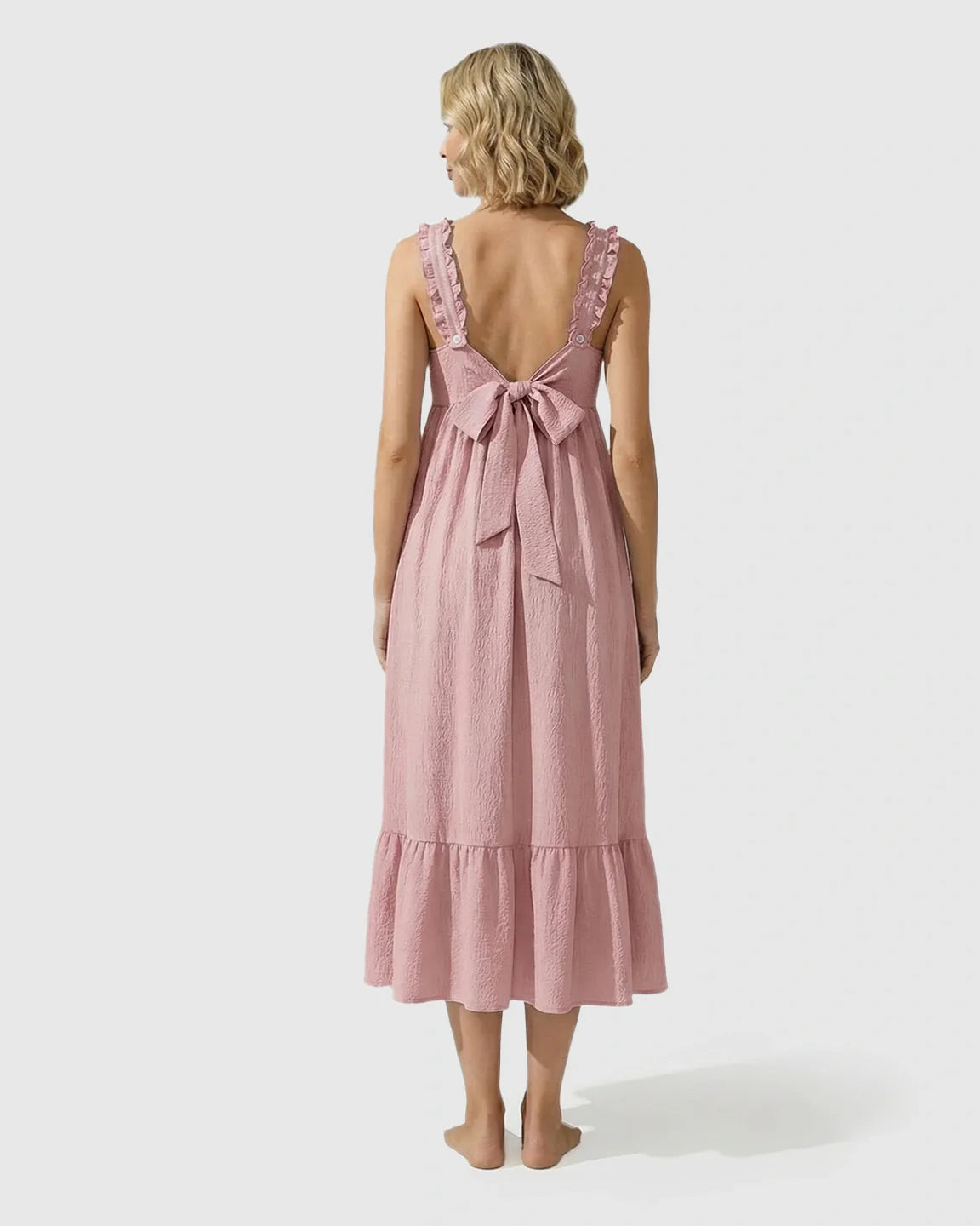 Pink ruffled strap maternity maxi dress with back tie bow and tiered skirt.