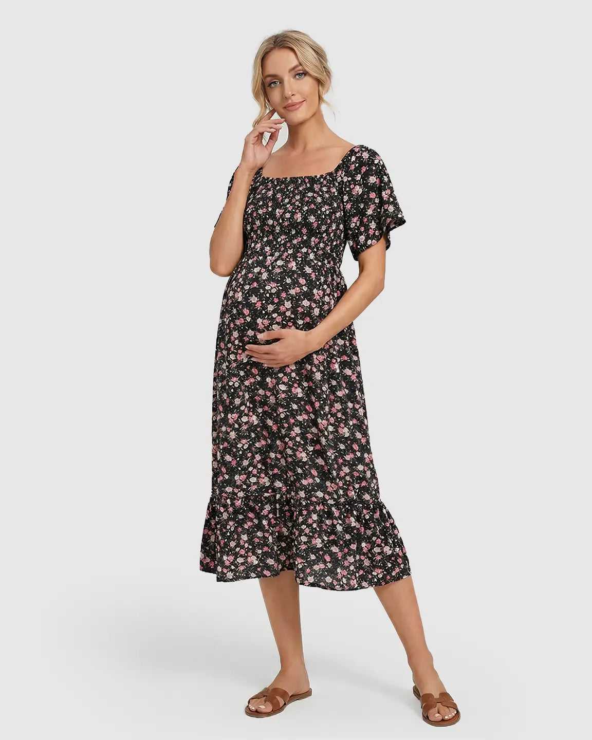 Maternity midi dress in black with pink floral print, flutter sleeves, and smocked bodice.