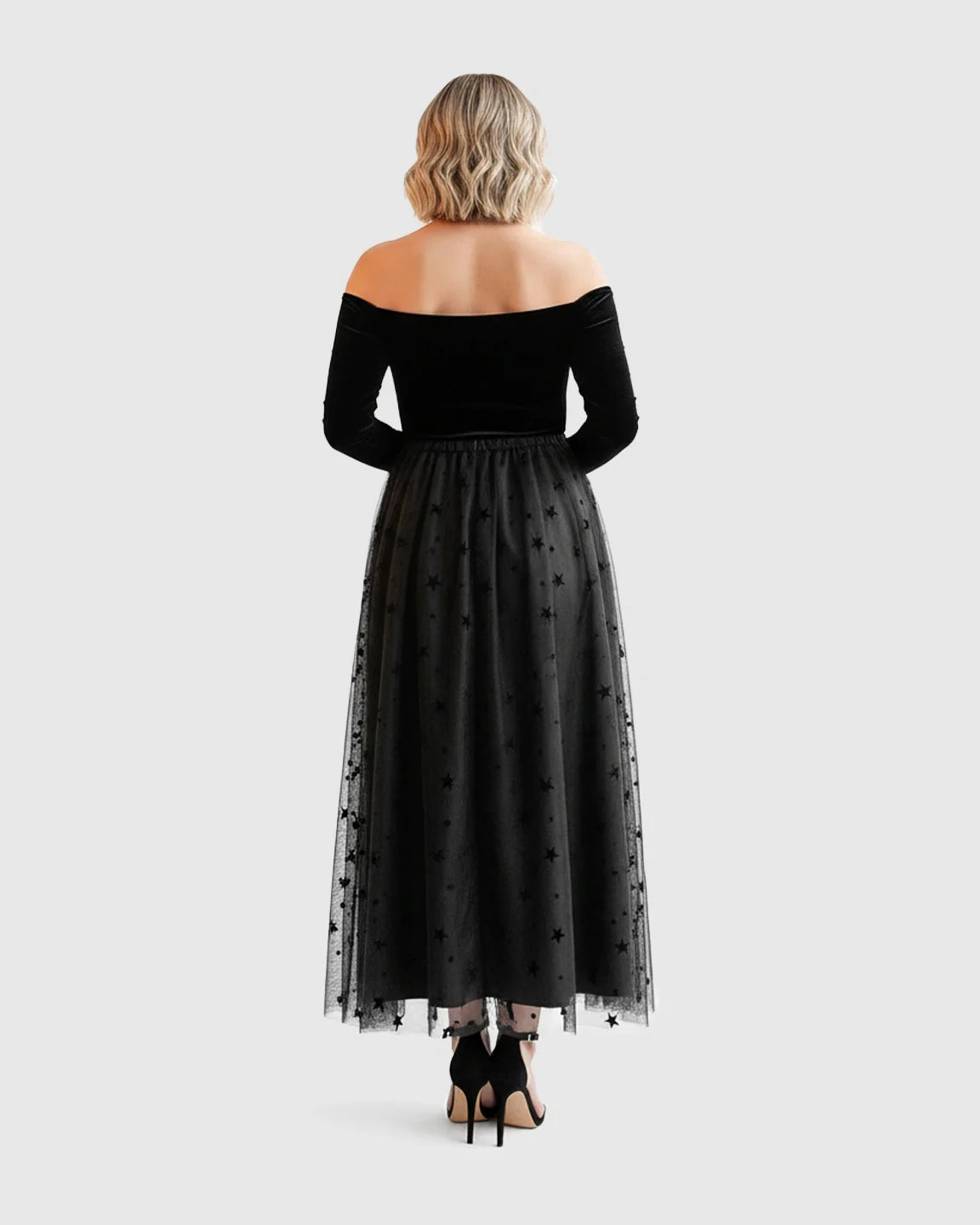 Black off-shoulder maternity midi dress with velvet bodice and star-flocked mesh skirt.