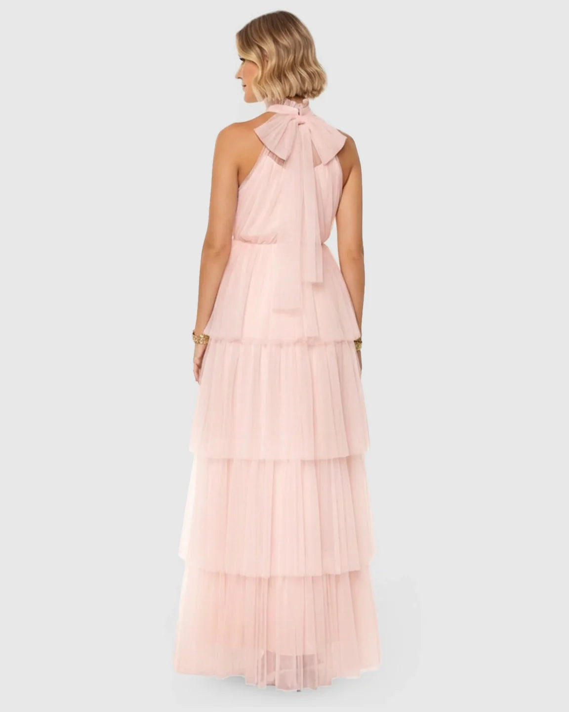 Pink halter neck tiered mesh maternity gown with a large back bow.