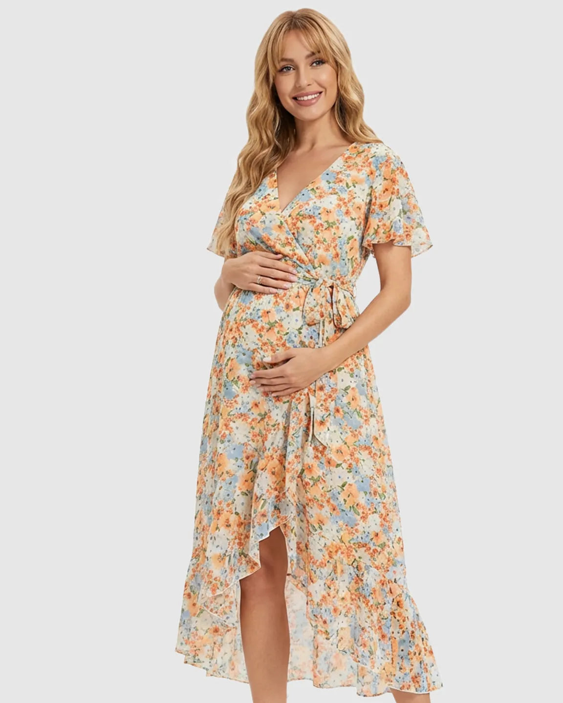 Smiling pregnant woman in a floral V-neck ruffled hem maternity midi dress.