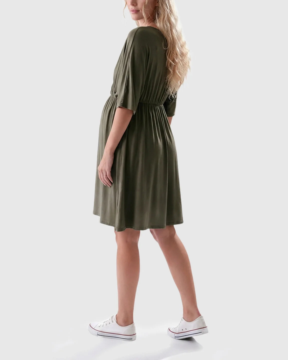 Woman in a relaxed olive green maternity midi dress with a gathered waist and elbow-length sleeves.