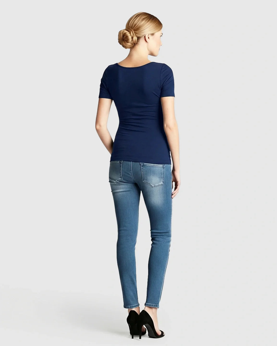 Woman from behind wearing a navy stretch-fit V-neck nursing t-shirt and jeans.