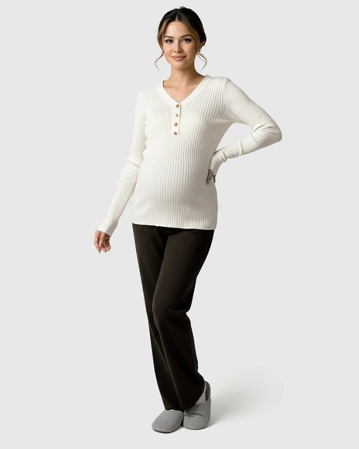 White ribbed V-neck maternity nursing sweater with gold buttons, paired with dark pants.