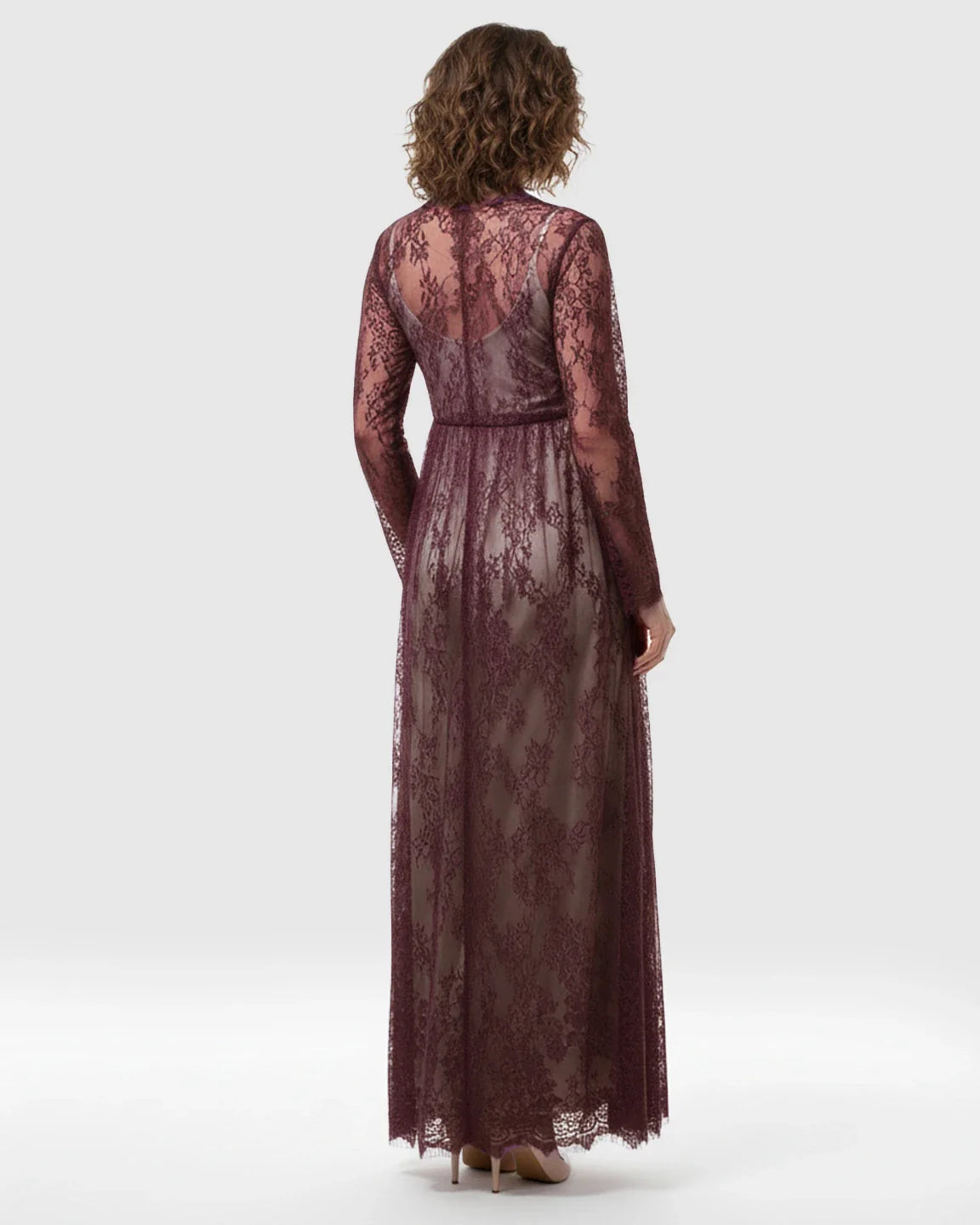 Maternity maxi dress in sheer floral plum lace with an empire waist and long sleeves, viewed from the back.