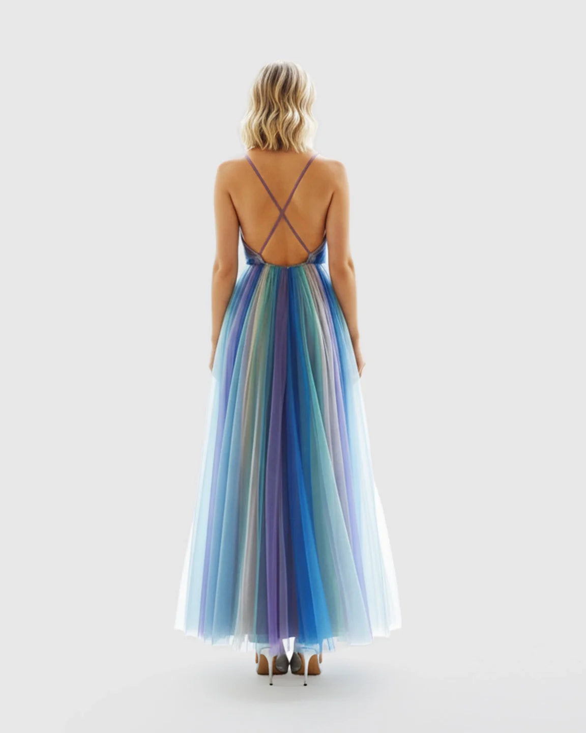 Woman in a flowy, colorful crisscross back empire waist maternity maxi dress with spaghetti straps.