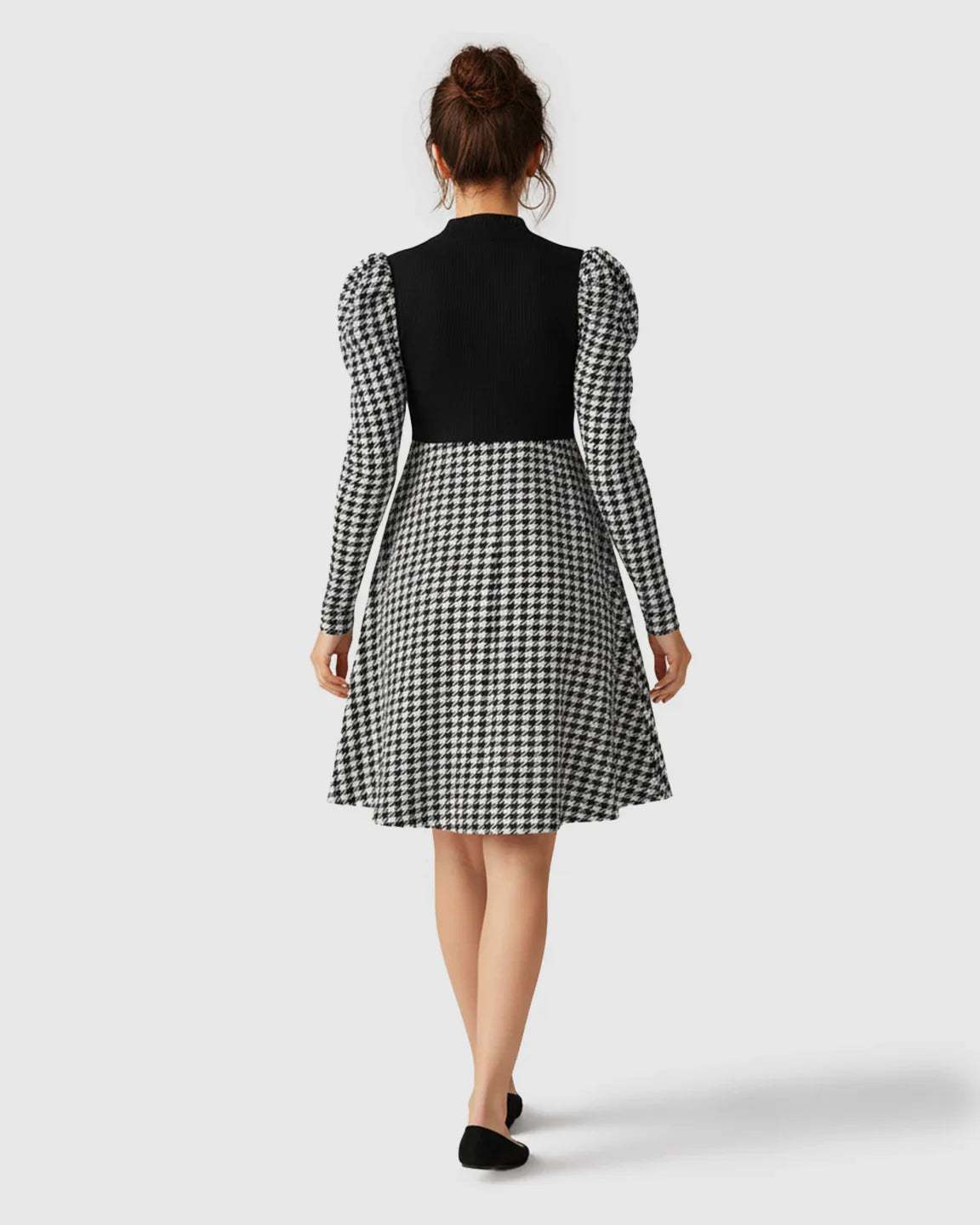 Elegant maternity short dress with black knit bodice, houndstooth skirt, and puff sleeves.