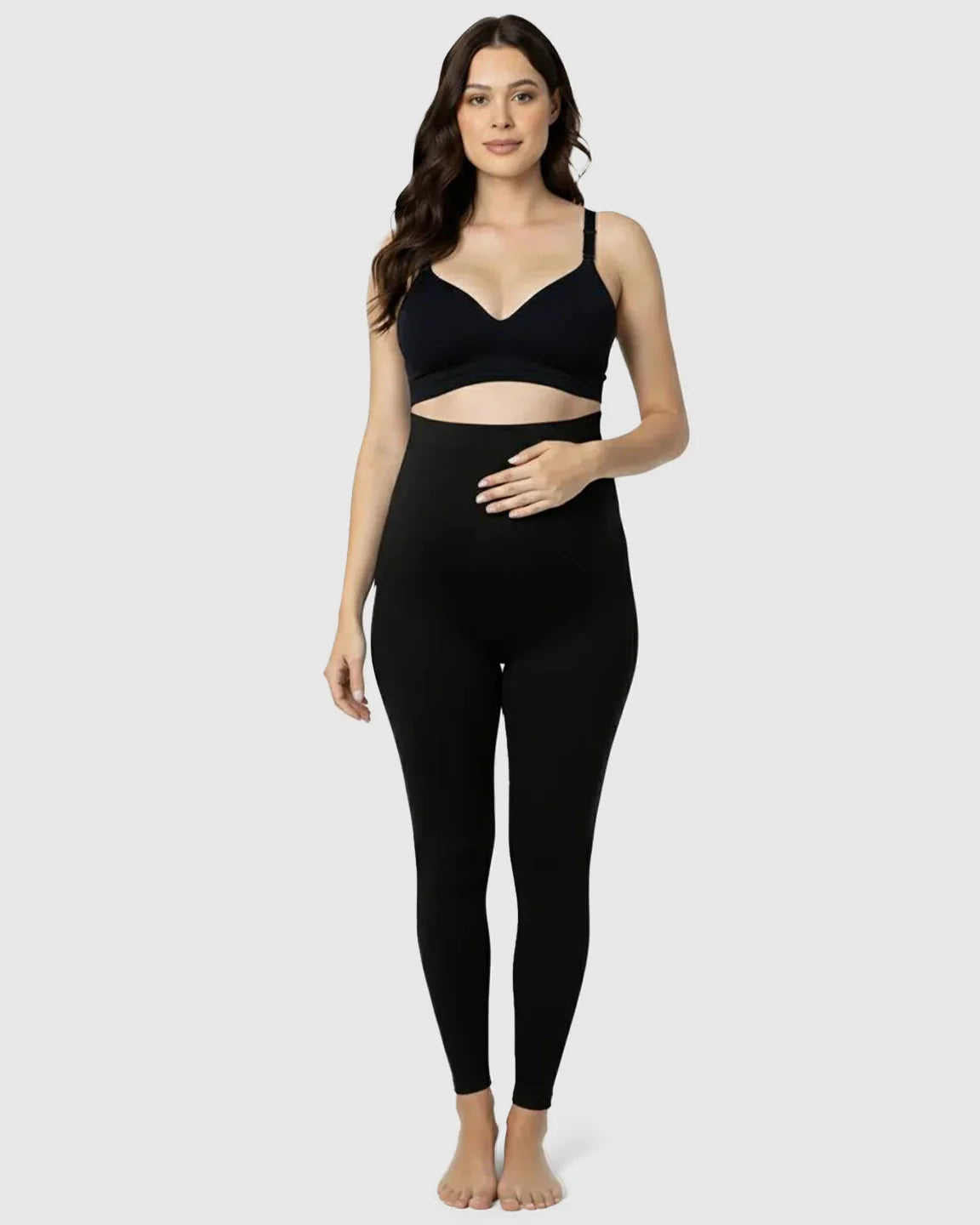 Woman in black Bump Society Belly Support Stretch Maternity Leggings with high-waist panel and matching bra.