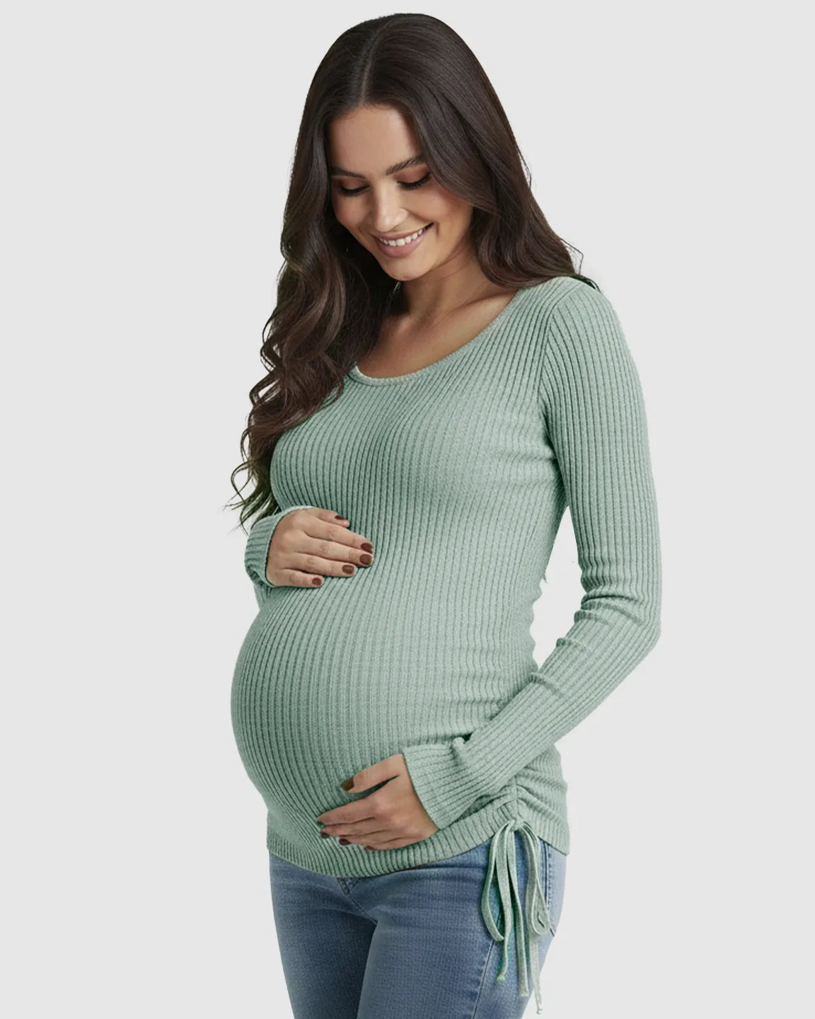 Smiling pregnant woman in a light green ribbed maternity top with adjustable side drawstrings.
