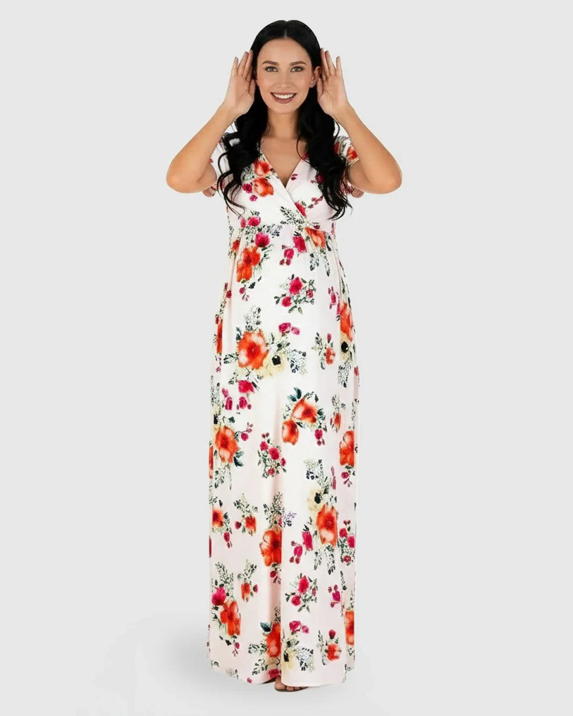 Smiling pregnant woman in a white floral V-neck short sleeve maternity maxi dress.