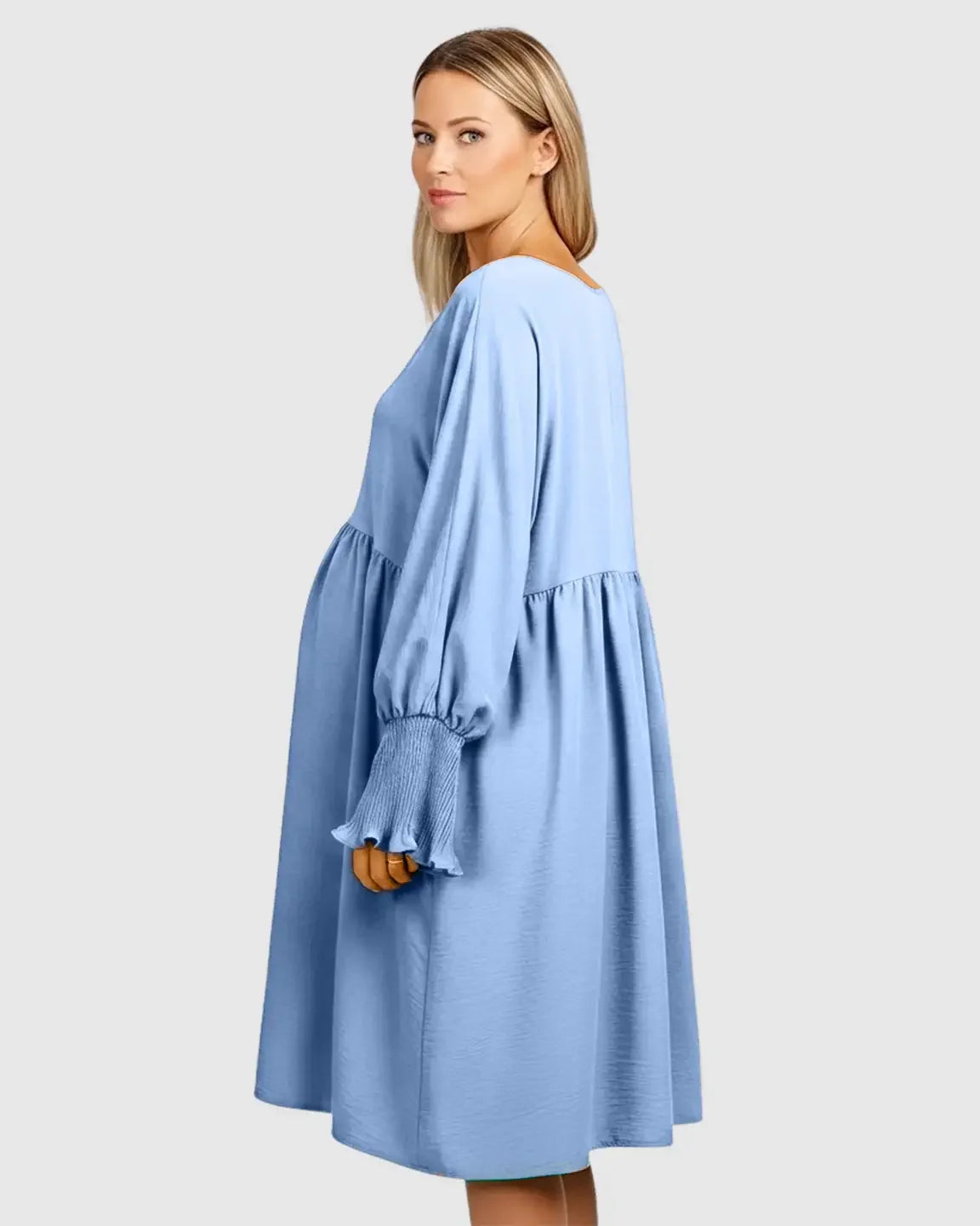 Pregnant woman in a blue smocked-sleeve casual maternity dress with a relaxed fit.