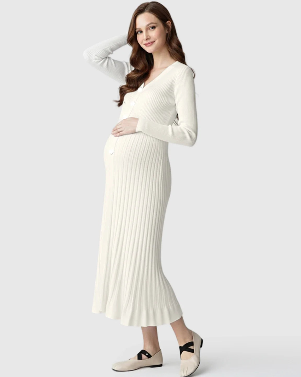 Smiling pregnant woman in a white ribbed knit maternity midi dress with long sleeves and V-neck.