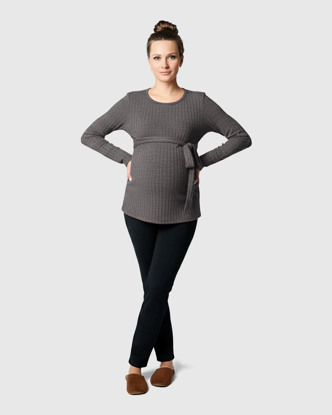 Pregnant woman in a gray ribbed tie-waist long sleeve maternity sweater and black pants.