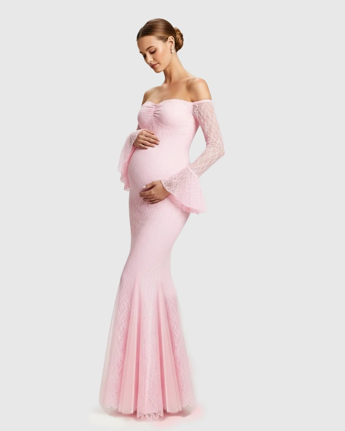 Pregnant woman in a pink off-shoulder lace mermaid maternity maxi dress with bell sleeves.