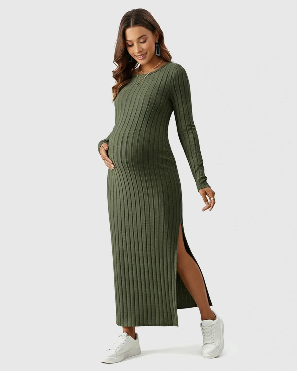 Pregnant woman in a long-sleeved olive green ribbed knit maternity maxi dress with a high side slit.