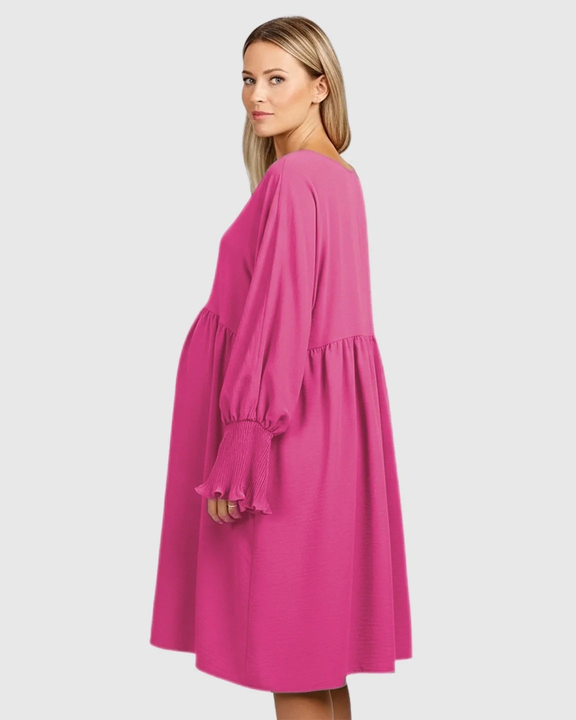 Pregnant woman in a pink smocked sleeve casual dress with a round neckline and flowing silhouette.