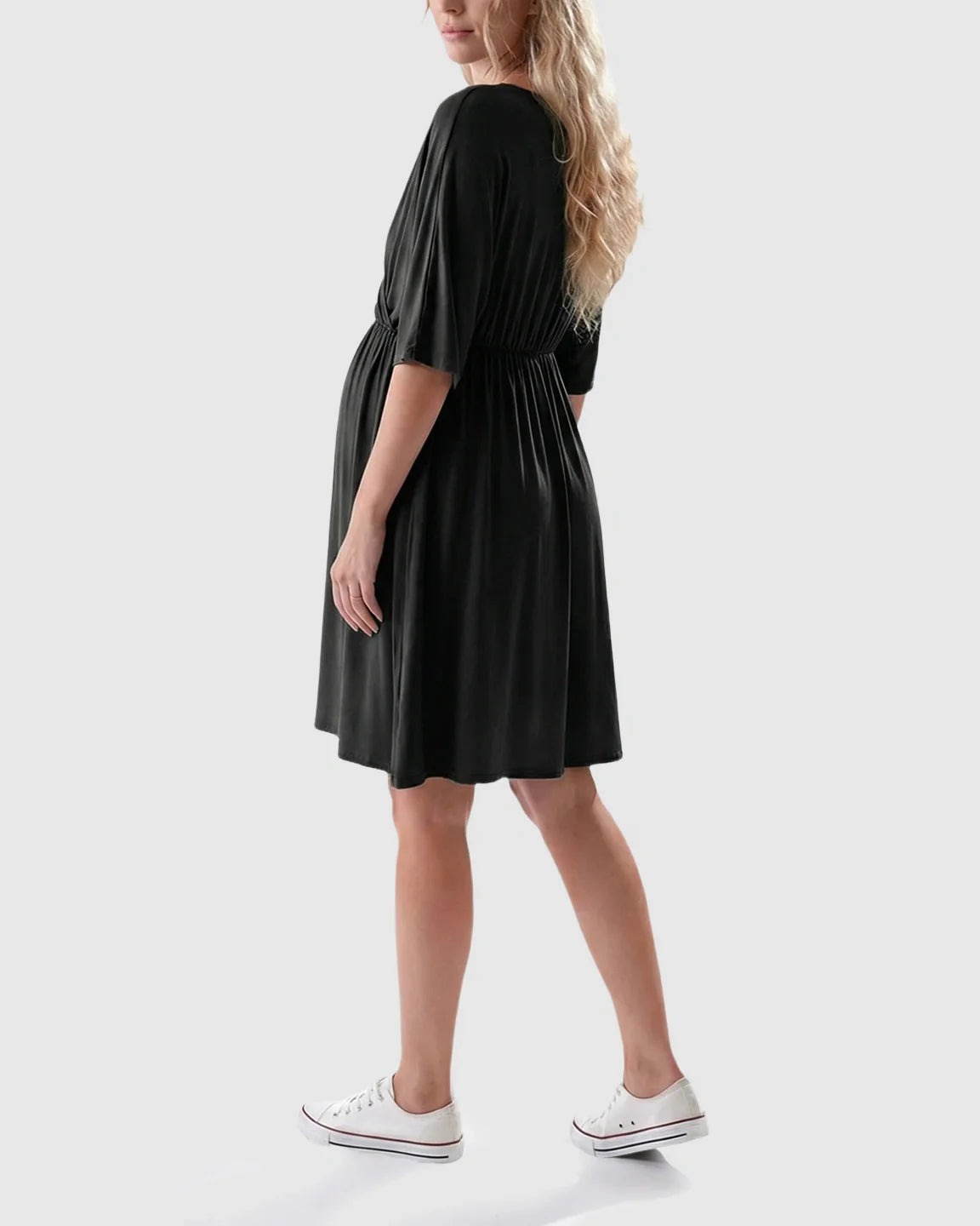 Black maternity midi dress with cross-front, 3/4 sleeves, and A-line silhouette, worn by a pregnant woman.