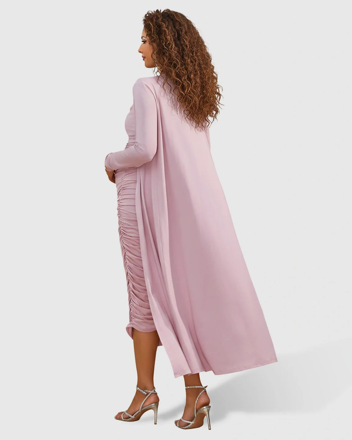 Maternity model in a pink side-ruched slip dress and long draped cardigan with silver heels.