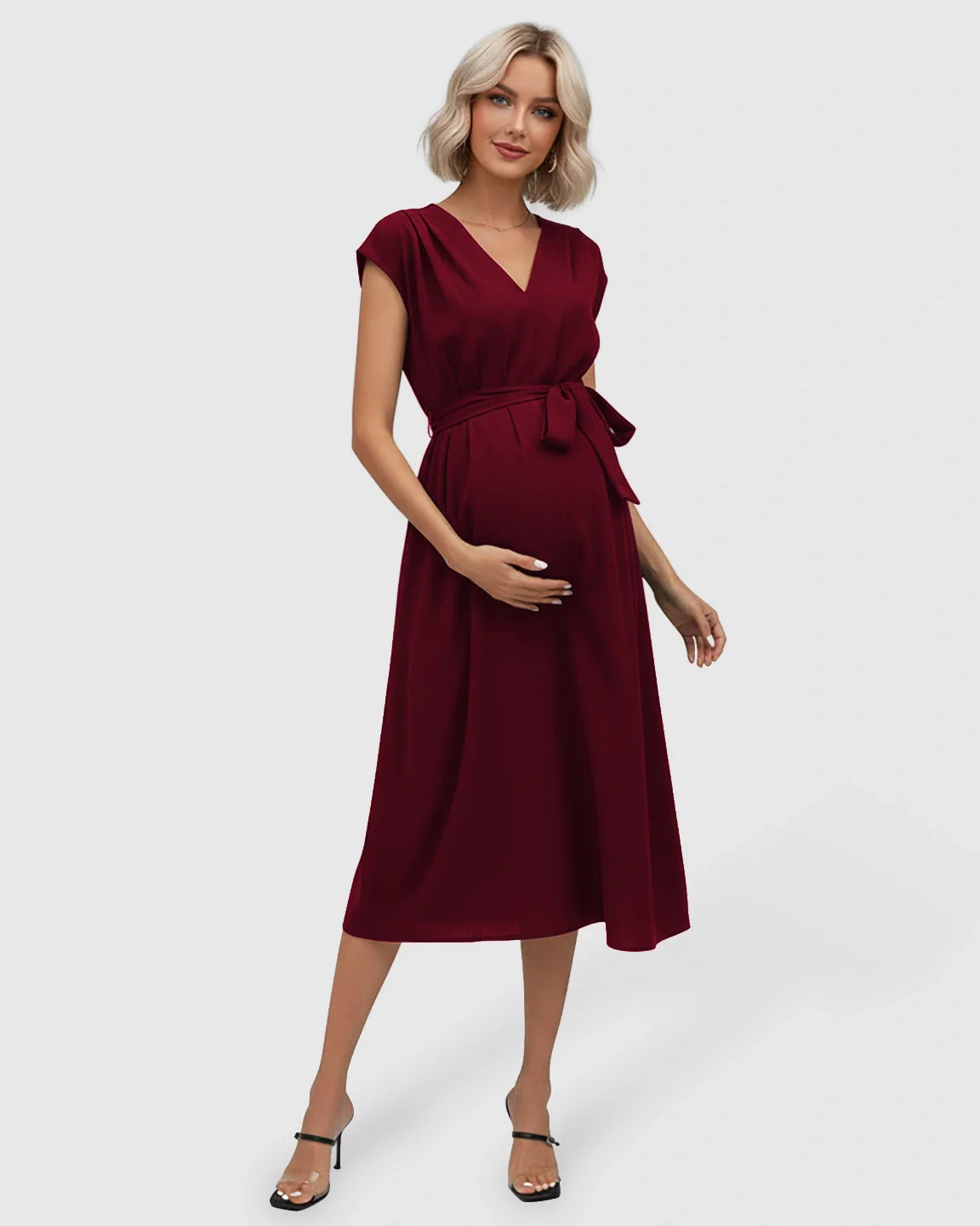 Pregnant woman in a red tie-waist V-neck maternity midi dress with flutter sleeves.