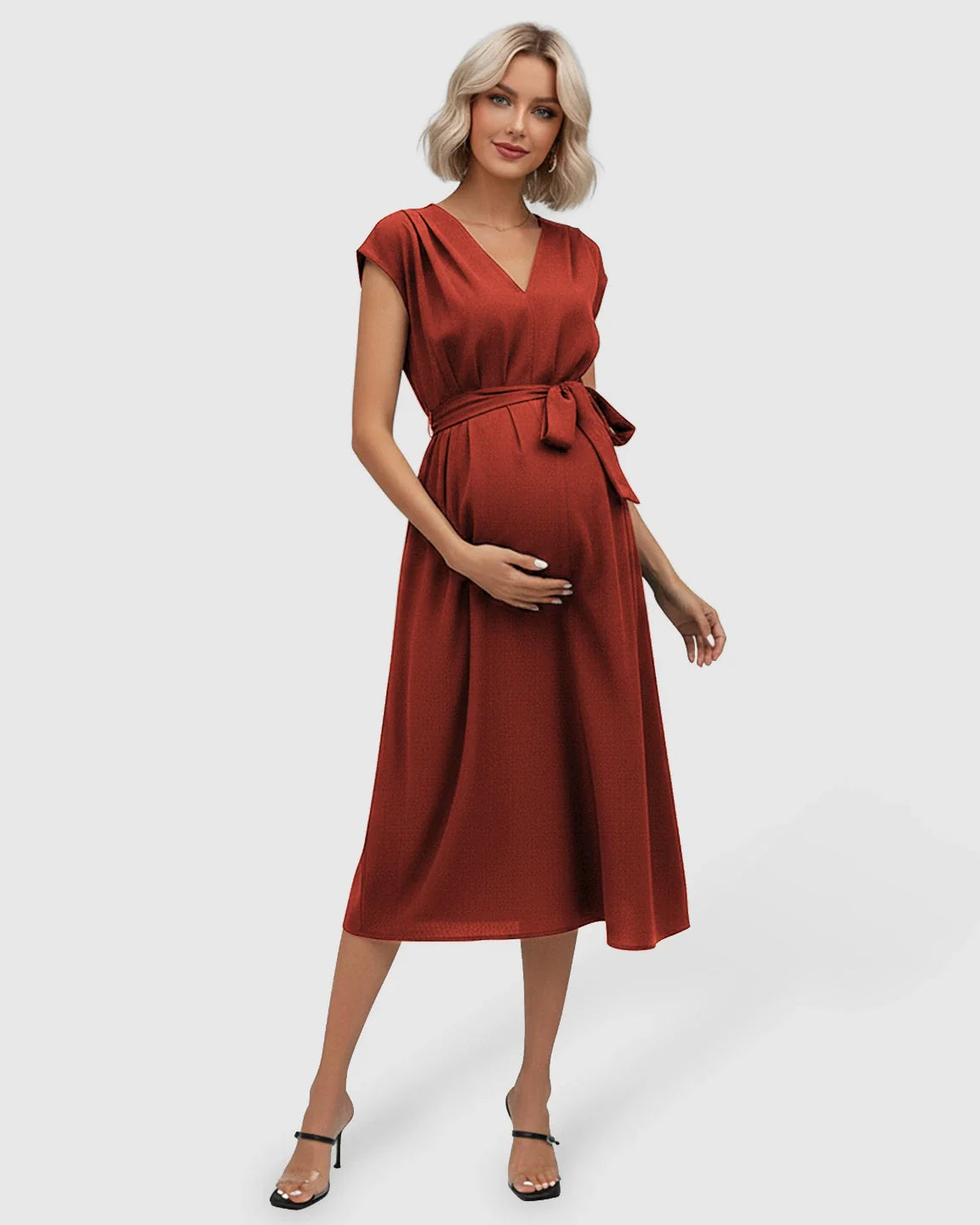 Pregnant woman in a rust-colored tie-waist V-neck maternity midi dress with flutter sleeves.