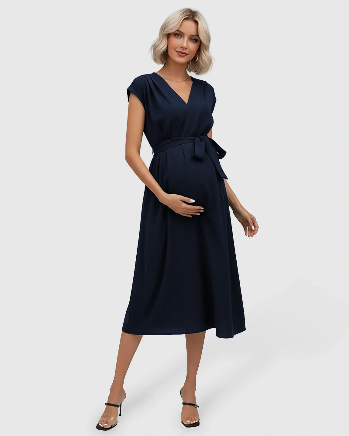 Navy V-neck maternity midi dress with flutter sleeves and adjustable tie-waist, worn by a pregnant woman.