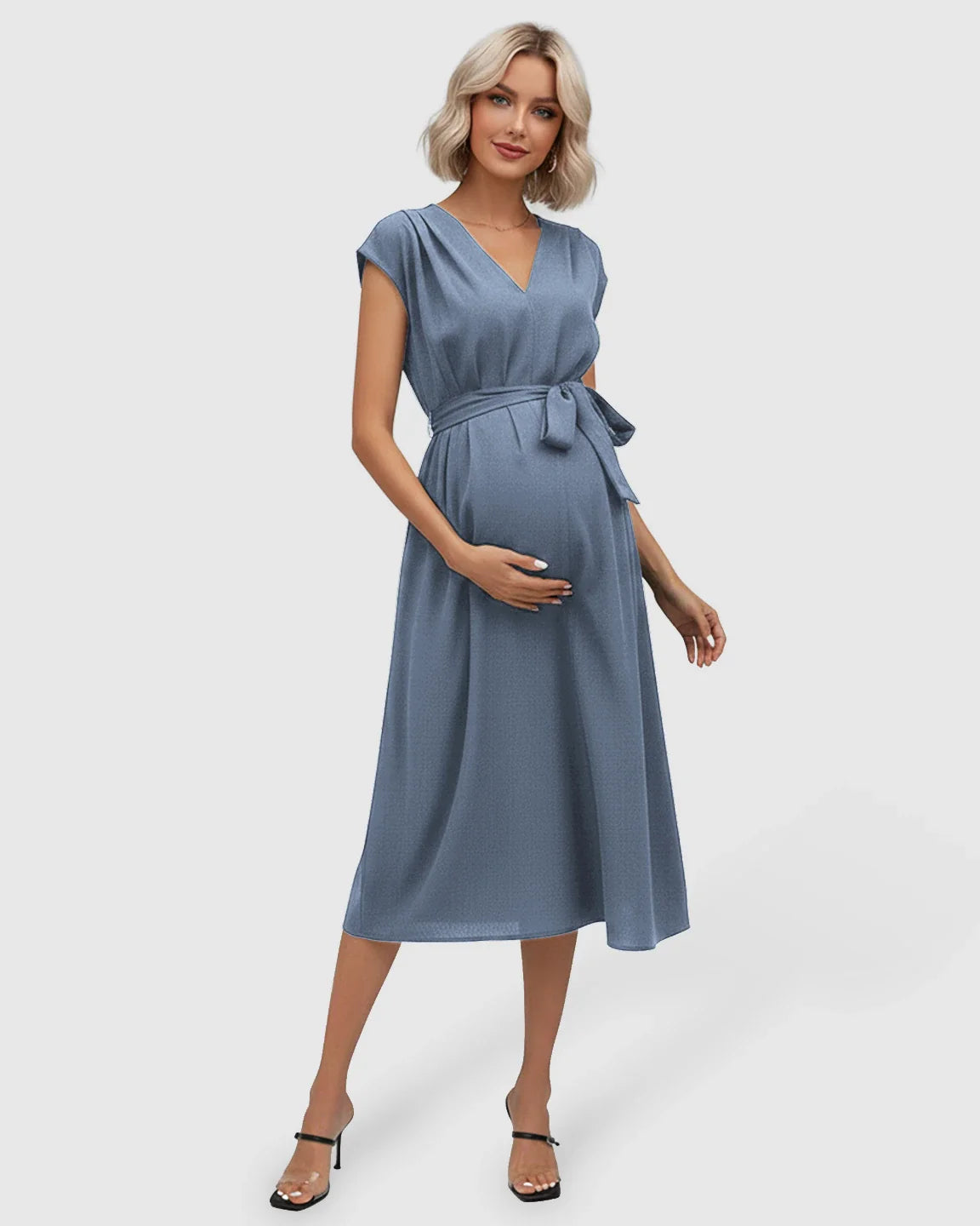 Maternity midi dress in dusty blue with V-neck, flutter sleeves, and adjustable tie-waist over a baby bump.