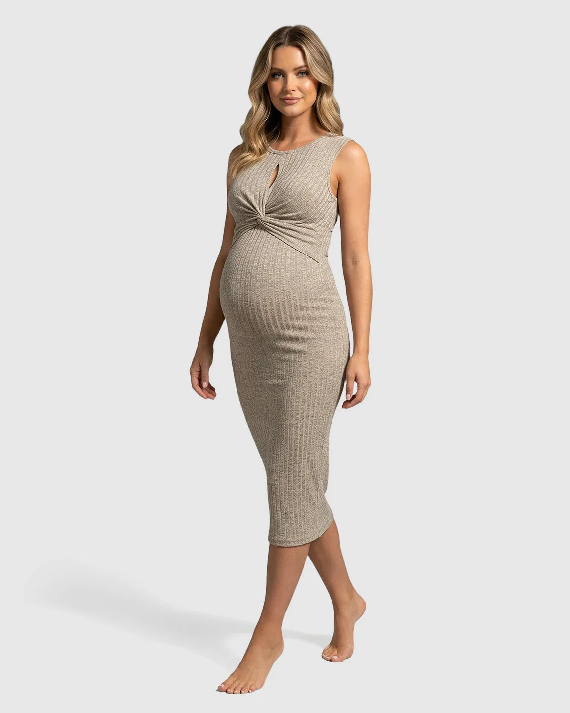 Pregnant woman in a beige ribbed bodycon maternity midi dress with a twisted chest detail.