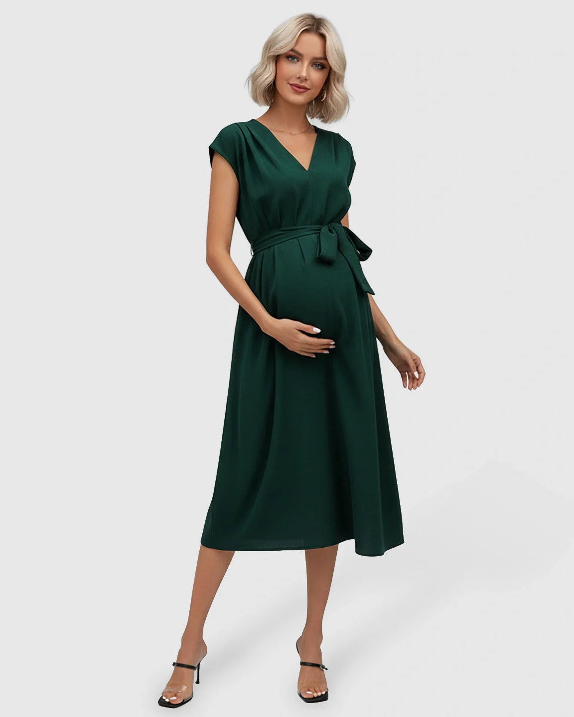 Pregnant woman in a dark green V-neck maternity midi dress with flutter sleeves and an adjustable tie-waist.