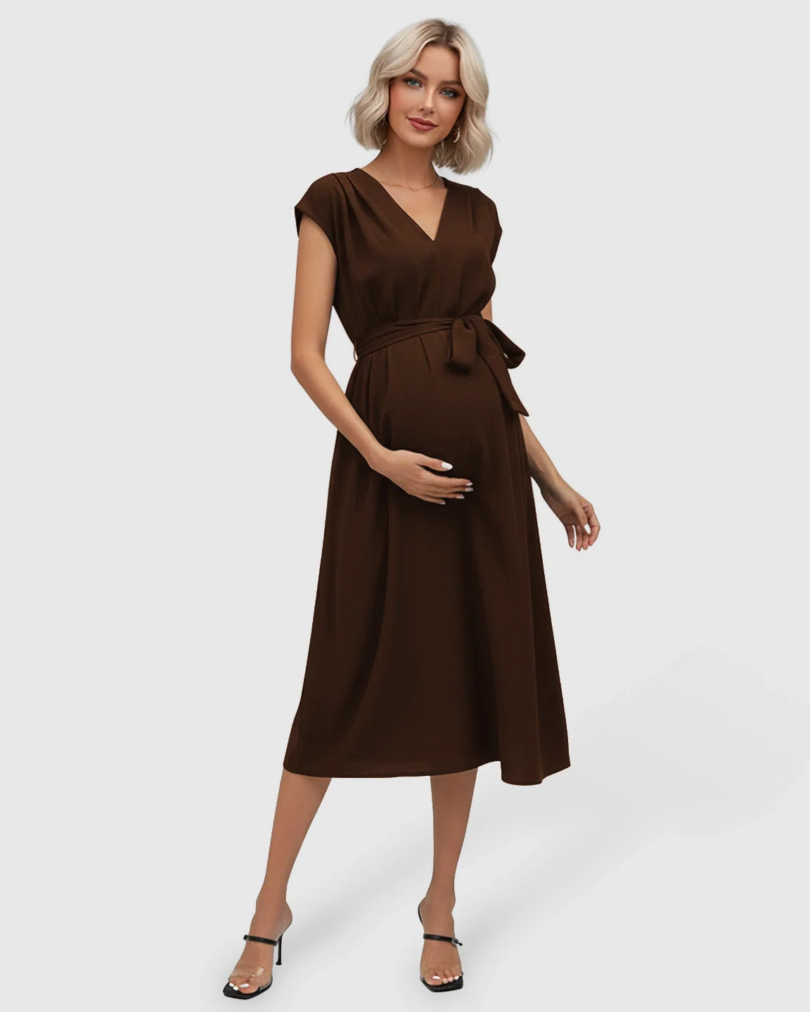 Maternity midi dress in brown with a V-neck, flutter sleeves, and adjustable tie-waist, worn by a pregnant model.