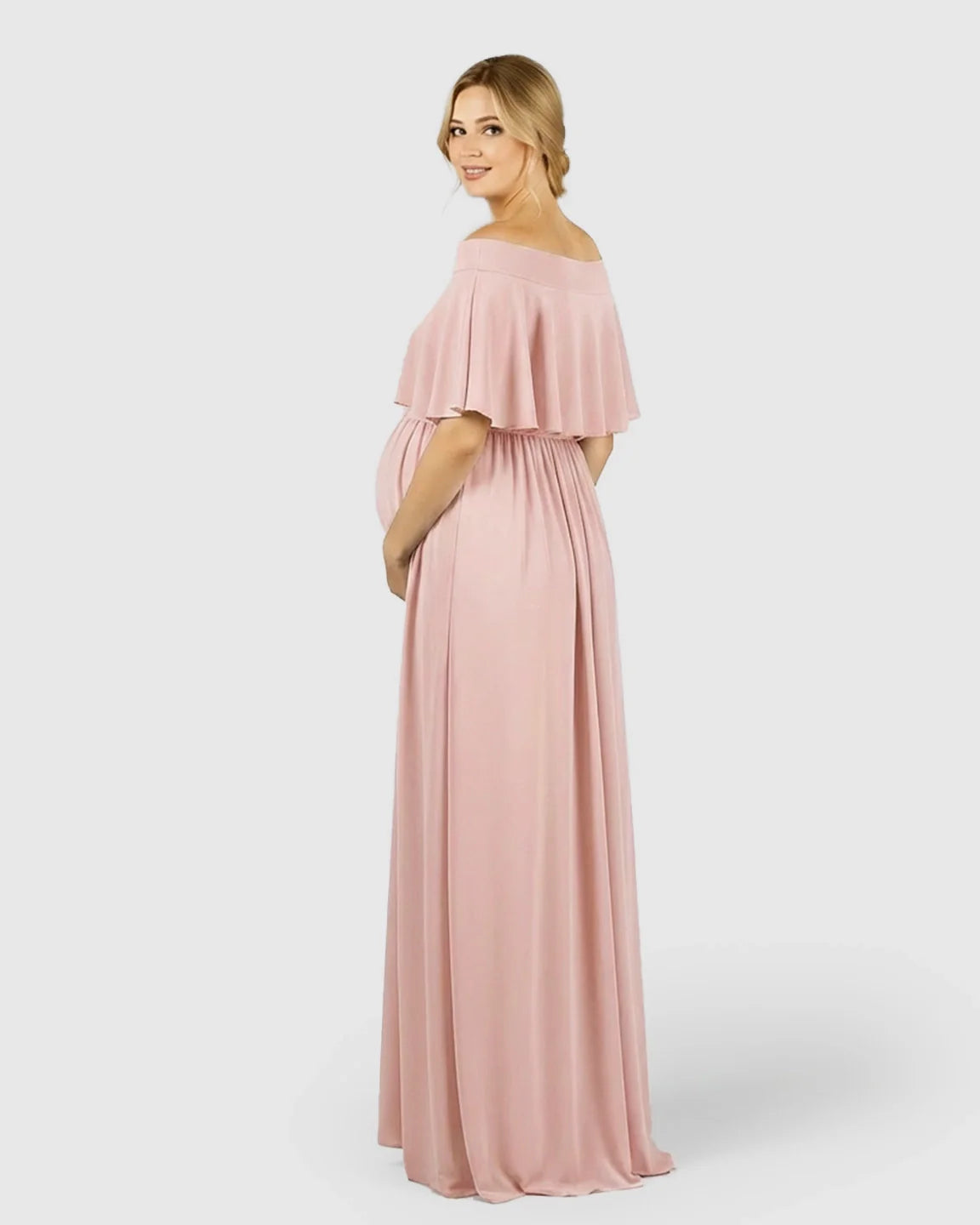 Blonde pregnant woman in a flowy, off-shoulder blush pink chiffon maternity photoshoot dress.