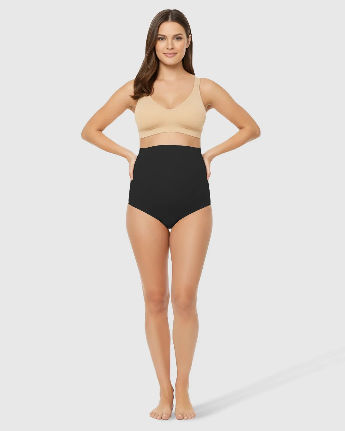 Woman in black high-waist seamless belly-support maternity underwear and a nude bra.