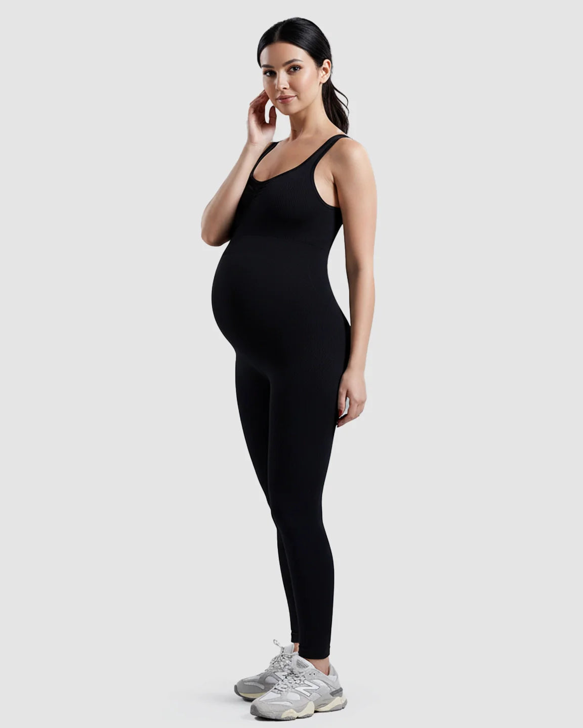 Black ribbed high-waisted stretch maternity bodysuit on a pregnant woman.
