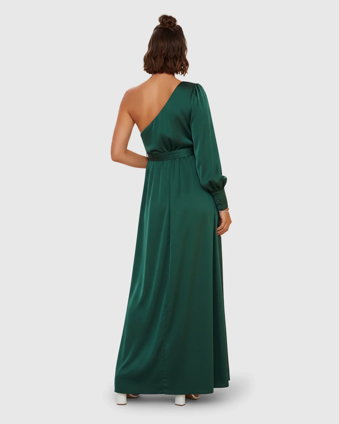 Emerald green satin one-shoulder maternity maxi dress with a long sleeve, tie-waist, and flowing silhouette.