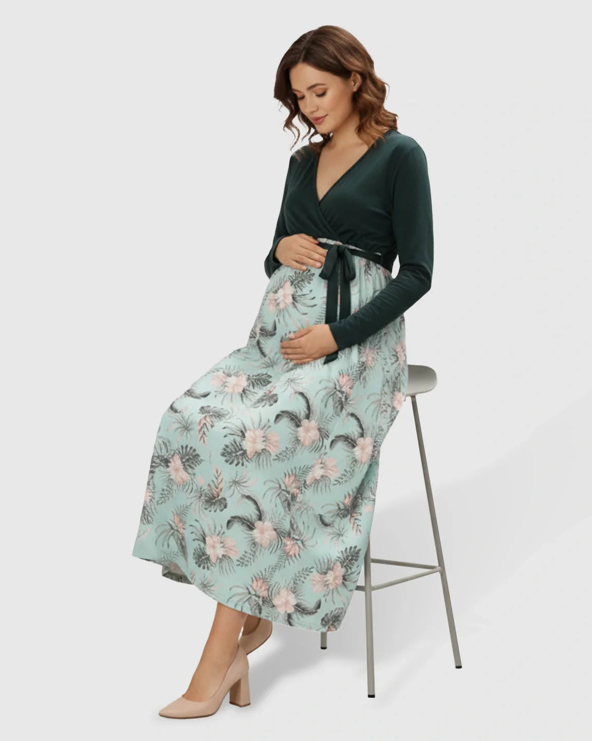 Maternity midi dress: deep green V-neck top, flowing light green floral skirt, tie waist, long sleeves.