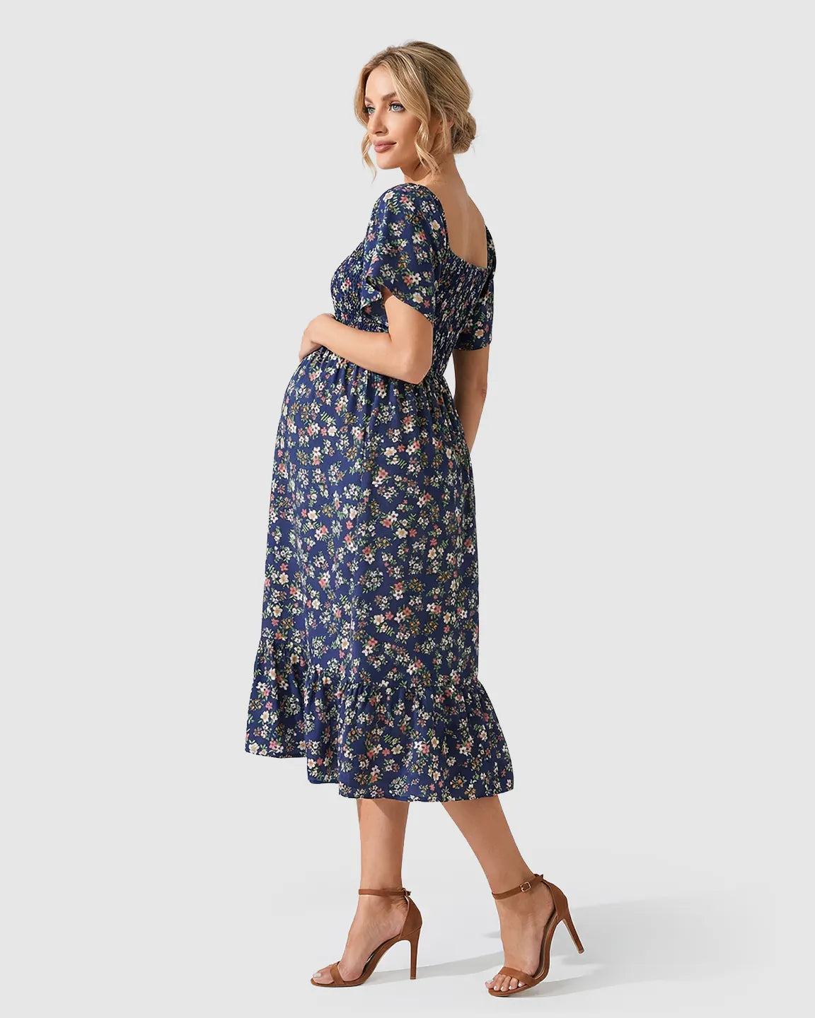 Maternity midi dress in navy floral print with flutter sleeves, smocked bodice, and tiered skirt.