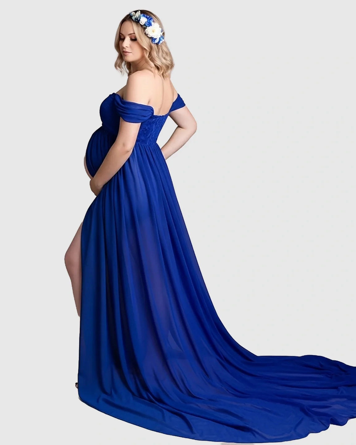 Pregnant woman in a royal blue off-shoulder chiffon maternity gown with a long train and thigh-high slit.