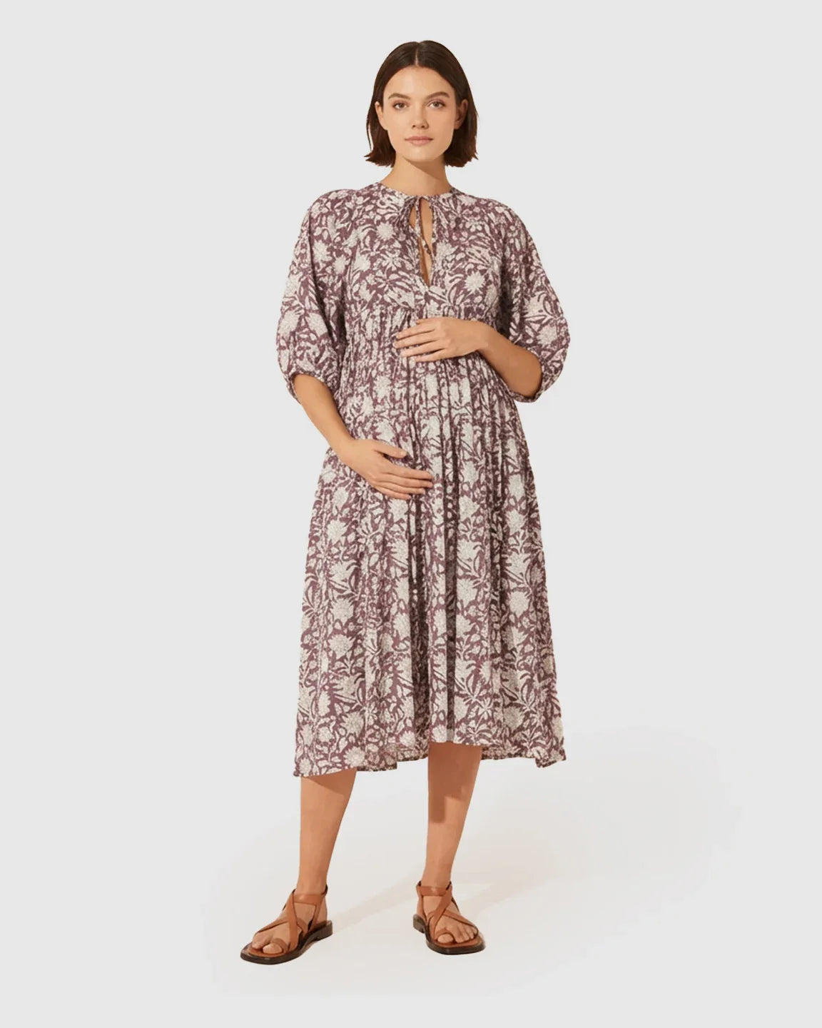 Maternity midi dress with gathered shoulders, floral print, loose fit, puff sleeves, and knot detail.