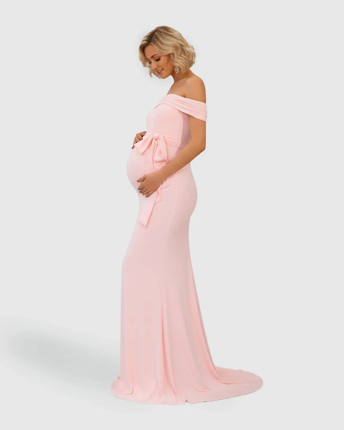 Pink off-shoulder maternity photoshoot gown with adjustable tie-waist and flowing fishtail hem.