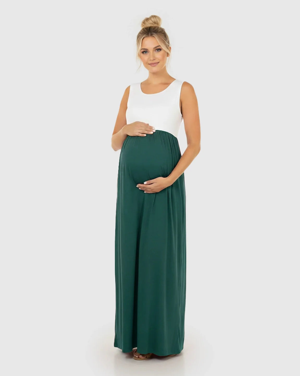 Pregnant woman in a white and dark green colorblock high-waisted maternity maxi dress, smiling.