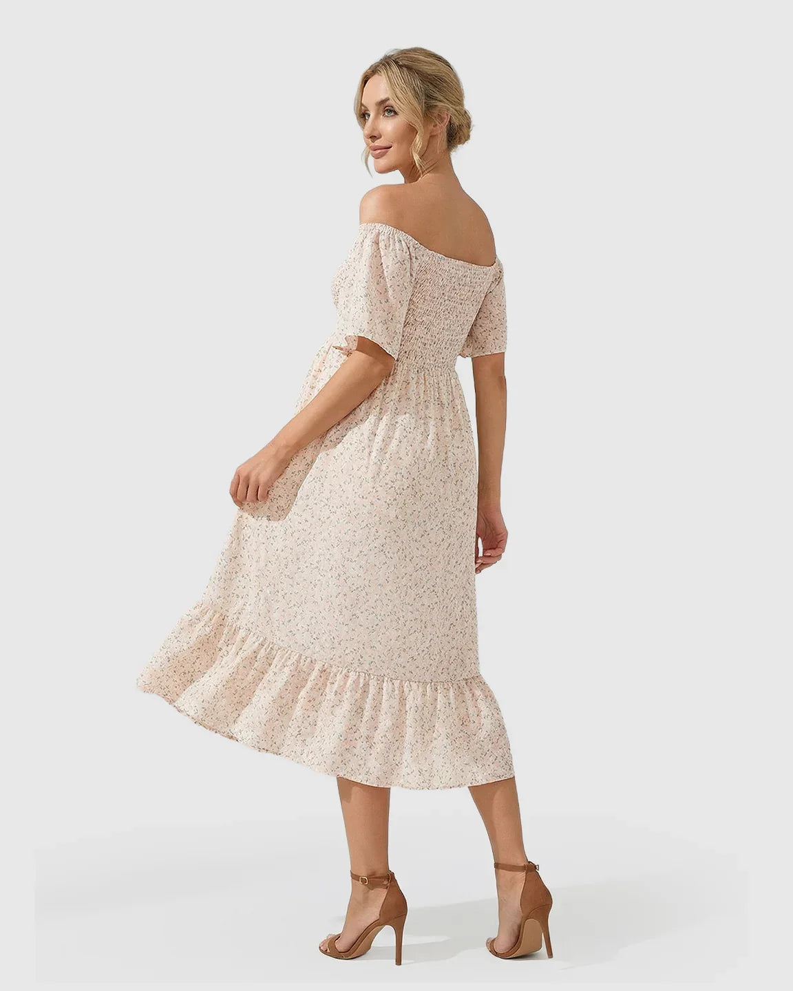 Blonde pregnant woman in a light pink floral flutter-sleeve smocked maternity midi dress with a tiered skirt.