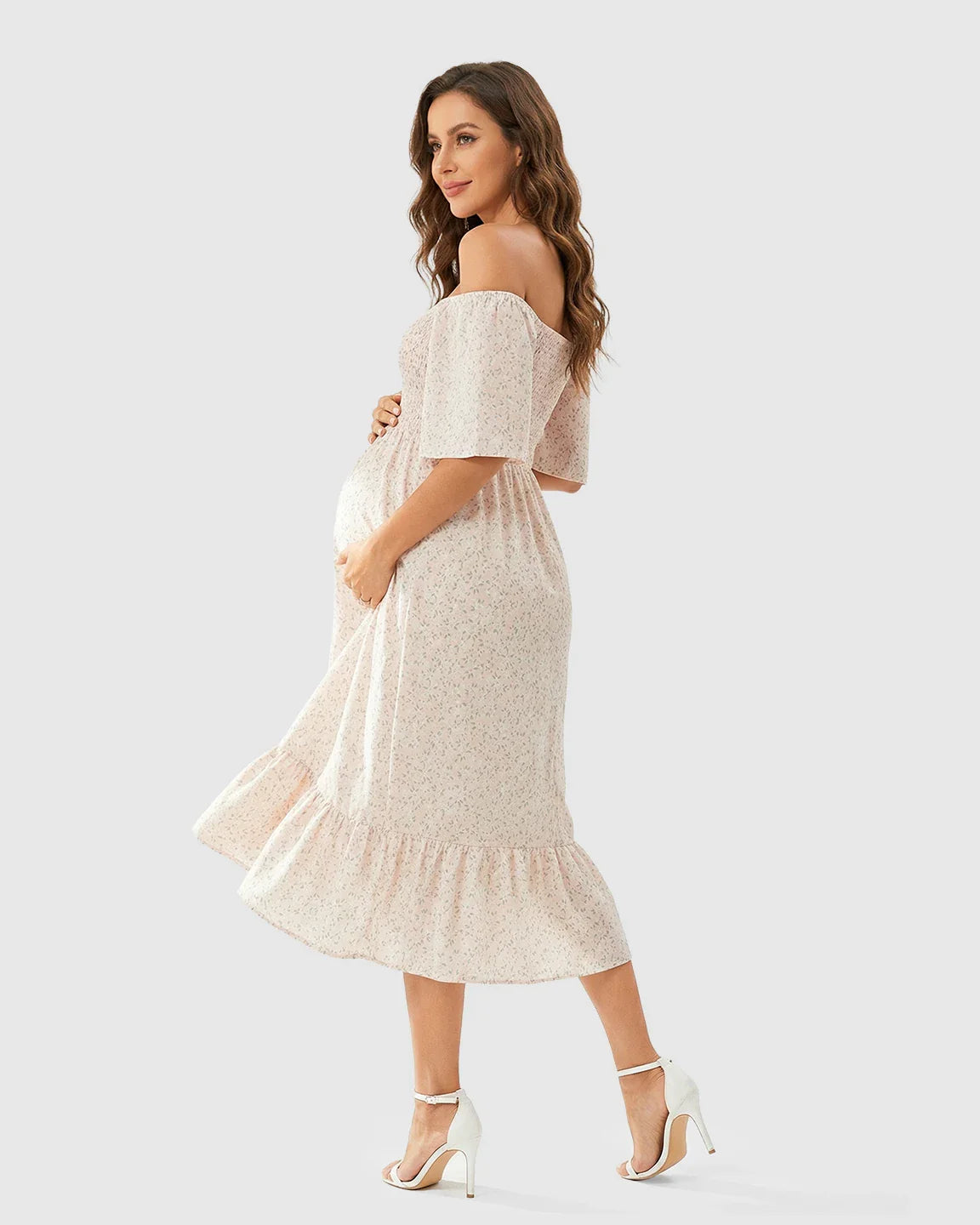 Maternity midi dress with pink floral print, off-shoulder smocked top, flutter sleeves, and tiered skirt.