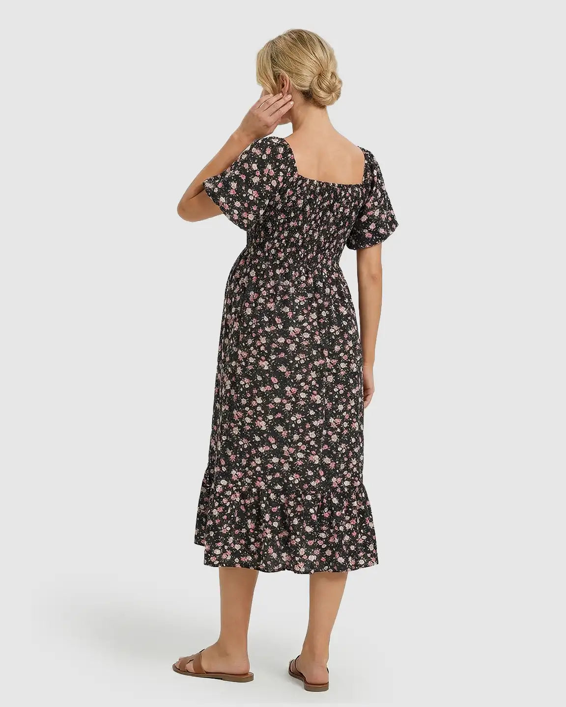 Black floral flutter-sleeve smocked maternity midi dress with pink flowers and a tiered skirt.