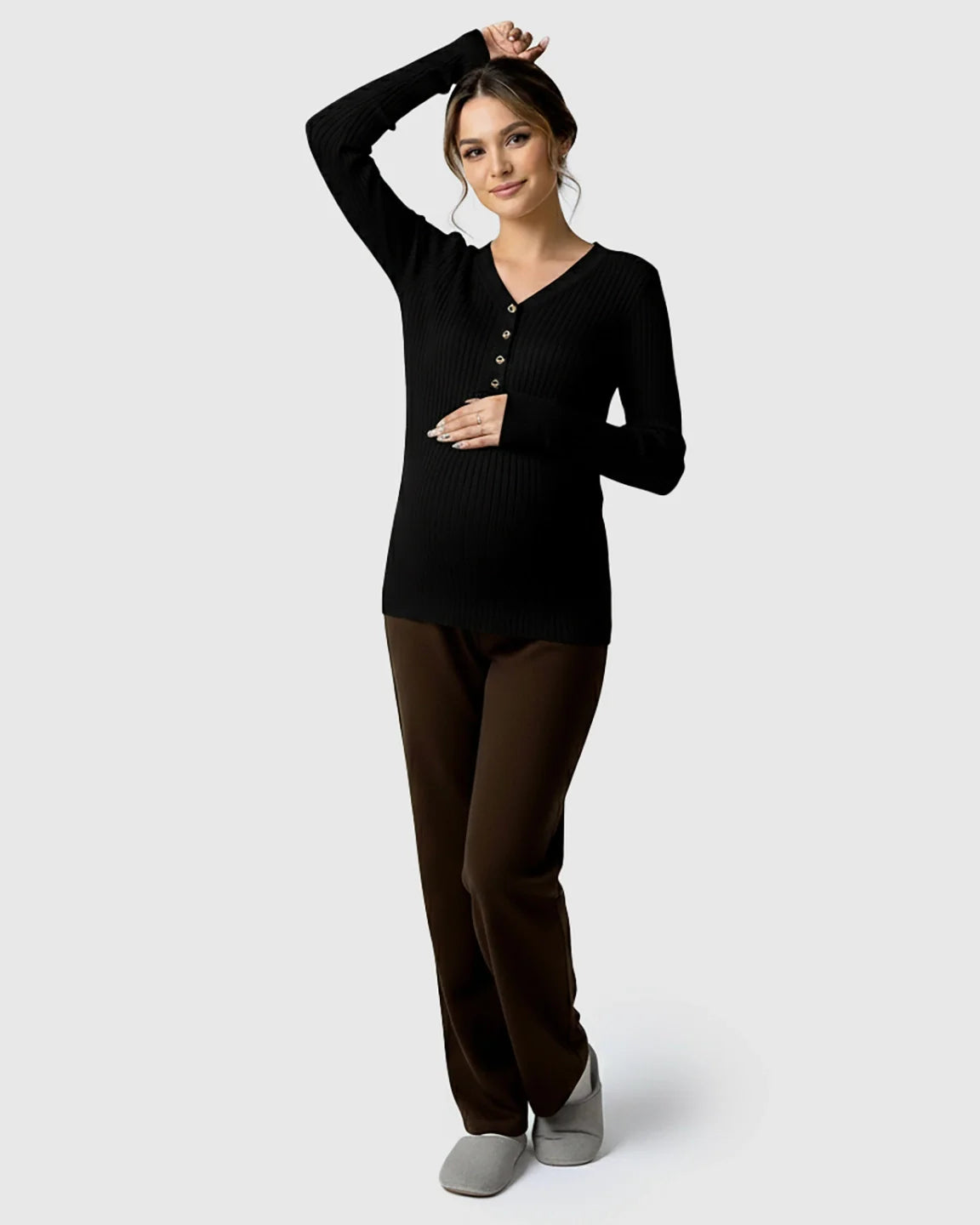 Black ribbed V-neck maternity nursing sweater with gold buttons, paired with brown pants.