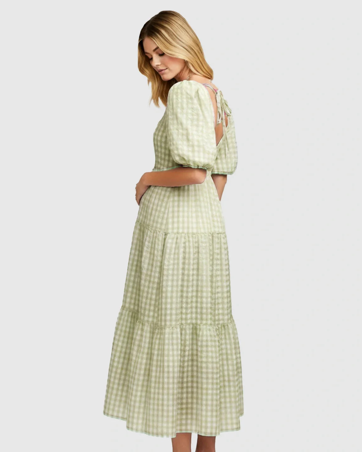 Blonde woman in a light green and white checkered maternity maxi dress with puffed sleeves and a tie-back.