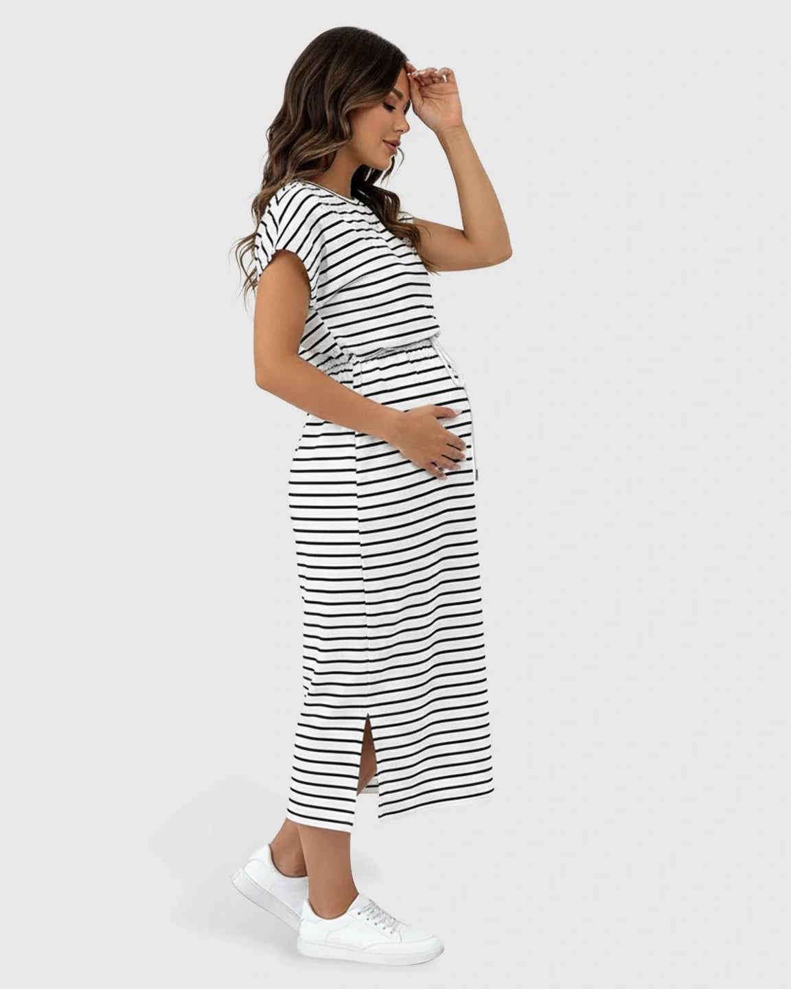 Maternity midi dress: pregnant woman in black and white striped cap sleeve dress with adjustable waist and side slit.