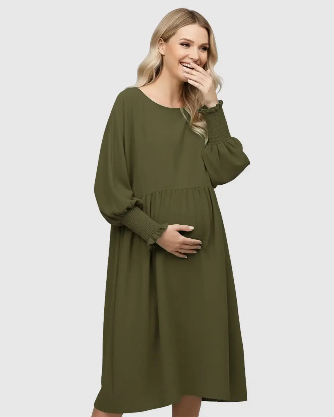 Smiling pregnant woman in a flowy olive green smocked sleeve casual maternity dress.