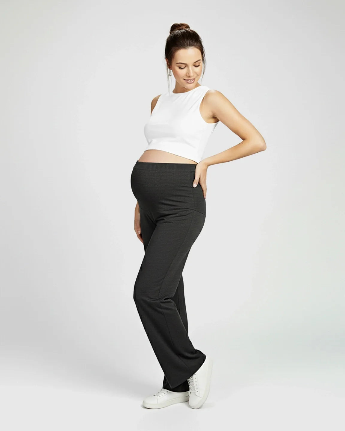 Pregnant woman in dark grey Comfort Fit elastic waist maternity pants and white top.
